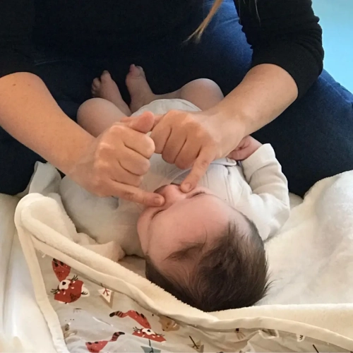 Maman qui masse le nez de son bébé lors d’un atelier massage bébé à Villenave-d’Ornon